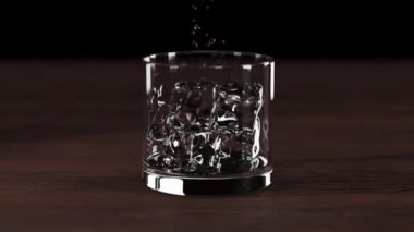 Viski bardağa buzla doluyor. Sığ alan derinliğinde sıvı akışı. 3d hazırlayıcı.