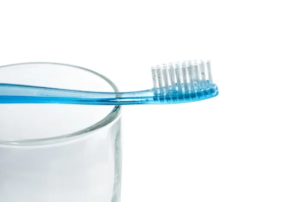 Blue tooth brush lies on a glass on white background — Stock Photo, Image