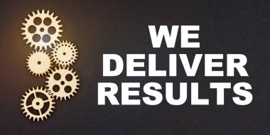 İş ve endüstri kavramı. Siyah bir arkaplanda, dişliler ve yazıtlar - Biz DELIVER SONRA