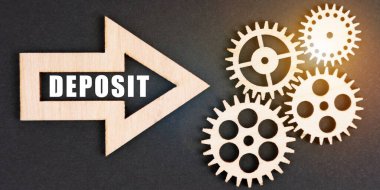 İş ve finans kavramı. Siyah bir arkaplanda, dişliler ve üzerinde yazı olan bir ok - DEPOSIT
