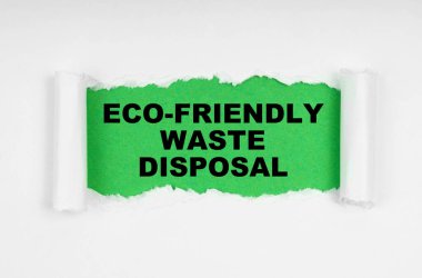 Çevresel konsept. Beyaz çarşafın ortasında, kağıt yırtılmış, yeşil bir arka planda yazılıydı - çevre dostu atık imhası.