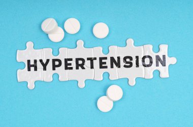 Tıp konsepti. Mavi arka plan hapları ve yazıtla ilgili bulmacalarda - HYPERTENSION