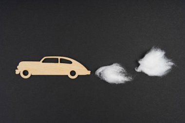 Çevresel konsept. Karbondioksit emisyonu olan ahşap bir araba. Pamuk yünü. Siyah bir arkaplanda izole edilmiş.