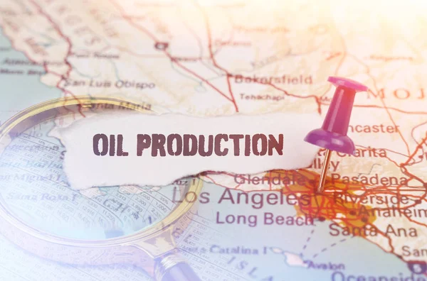 Business and industry concept. On the map, indicated by the Los Angeles button, next to it lies a magnifying glass and a piece of paper with the inscription - oil production
