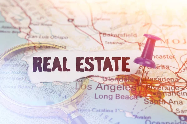 Business and industry concept. On the map, indicated by the Los Angeles button, next to it lies a magnifying glass and a piece of paper with the inscription - real estate