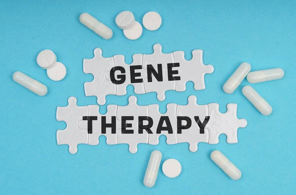 Medicine concept. On a blue background pills and puzzles with the inscription - GENE THERAPY