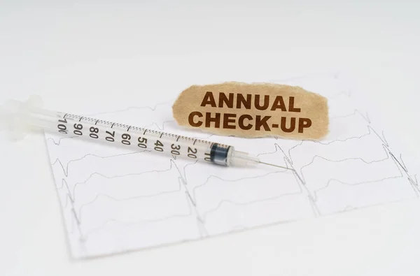 医学と健康の概念 テーブルの上には心臓グラム 注射器 碑文付きの紙があります 毎年チェックアップ — ストック写真