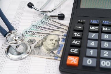 Steteskop, dolar, hesap makinesi ve kağıtlar üzerinde. Bankacılık işi. Mali analiz kavramı.
