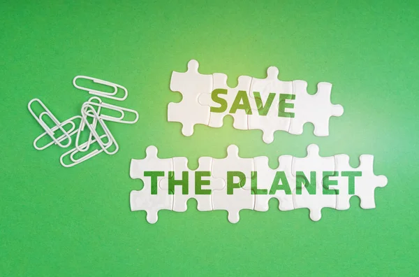 Ekologický Koncept Zeleném Pozadí Kancelářské Sponky Bílé Puzzle Nápisem Planet — Stock fotografie