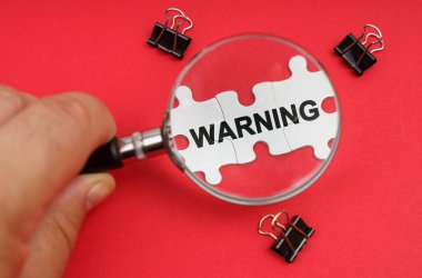 İş konsepti. Bir adam, bir büyüteçle bulmacaya bakar, yazıyla birlikte.