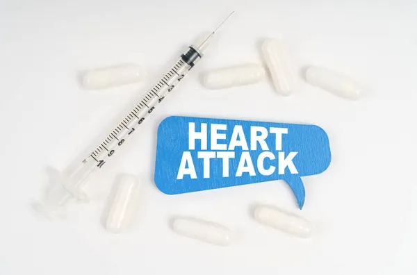 医学と健康の概念 白い背景の丸薬 注射器 銘板の青いプレート ハートアタック — ストック写真