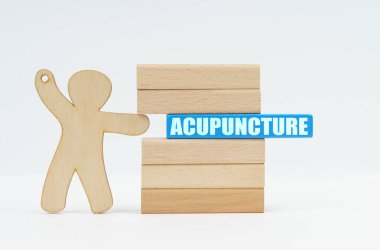 Tıp ve sağlık hizmetleri kavramı. Bir insan heykeli, bloklardan oluşan bir duvardan mavi bir ahşap bloğu itiyor..