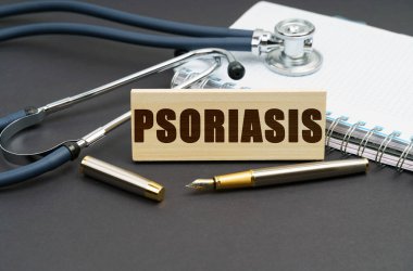 Tıp konsepti. Masanın üzerinde bir defter, bir steteskop ve PSORIASIS yazılı bir tabela var.