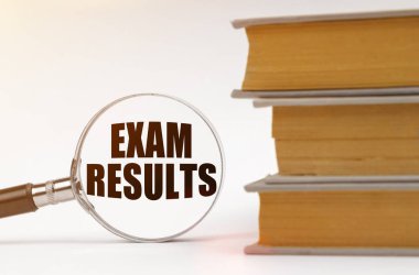 Eğitim konsepti. Beyaz arka planda, kitaplar ve içinde yazılı olduğu bir büyüteç - Sınav sonuçları