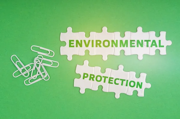 Экологическая Концепция Зеленом Фоне Скрепки Белые Головоломки Надписью Защита Окружающей — стоковое фото