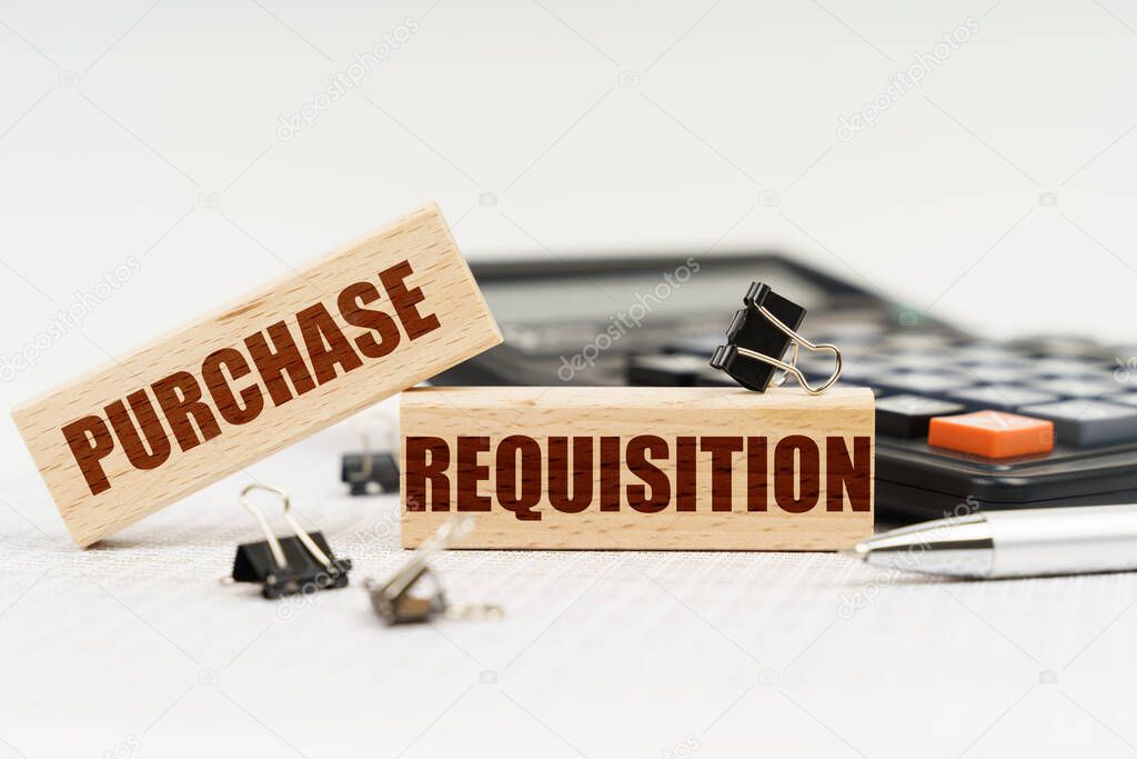 Business and finance concept. On a white background, a calculator, a pen, reports and wooden dies with the inscription - Purchase Requisition