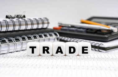 İş ve finans kavramı. Masanın üzerinde, ofis eşyalarının arasında, yazıtlı küpler - TRADE