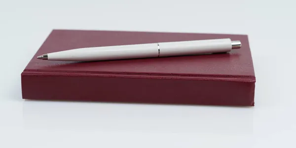 Concepto Educativo Sobre Fondo Blanco Una Libreta Roja Una Pluma — Foto de Stock