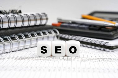 İş ve finans kavramı. Masanın üzerinde, ofis eşyalarının arasında, yazıyla birlikte küpler - SEO