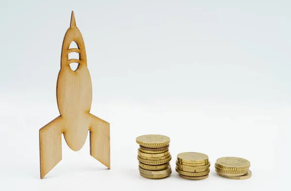 ビジネスと経済の概念 白い背景にロケットとコインの木製モデルがあります — ストック写真