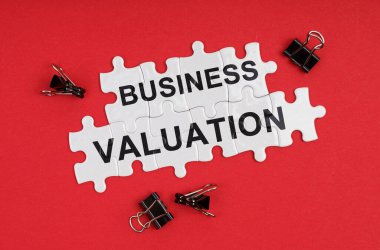 Business and Economics. On a red background, there are puzzles with the inscription - Business Valuation clipart
