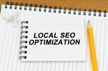 İş ve ekonomi kavramı. Masanın üzerinde iki defter ve bir kalem var. En üstteki notta, yerel Seo Optimizasyonu yazılıydı.