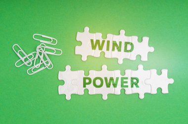 Ekoloji konsepti. Yeşil arkaplanda, ataçlar ve yazıyla birlikte beyaz bulmacalar - Rüzgar Gücü