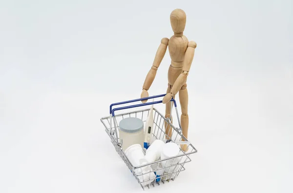 Business Concept Wooden Man Holds Shopping Basket Medicines Isolated White — Stock Photo, Image