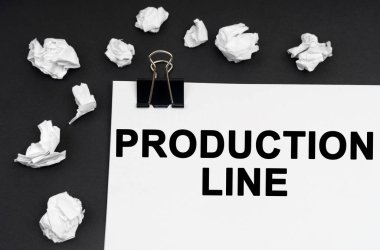 Sanayi konsepti. Siyah bir arkaplanda, üzerinde yazı olan buruşuk kağıt ve kağıt parçaları var - Üretim Çizgisi