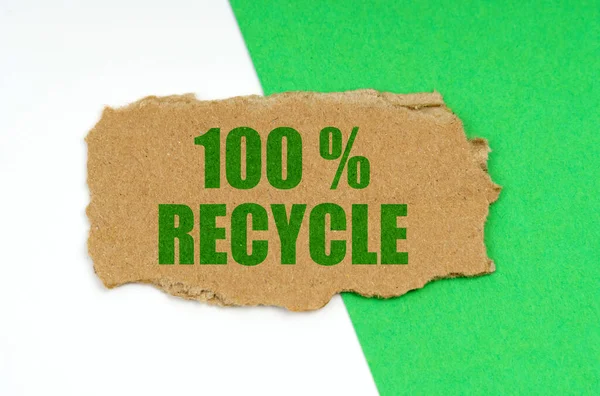 Em um fundo branco-verde encontra-se um pedaço de papelão com a inscrição - 100 reciclar — Fotografia de Stock