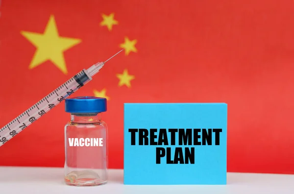 Vaccino, siringa e piastra blu con la scritta - PIANO DI TRATTAMENTO. Sullo sfondo la bandiera di China — Foto Stock