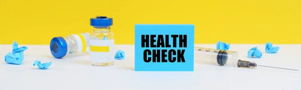 医学と健康の概念 テーブルの上には注射器 注射器 碑文の青い看板があります 健康チェック — ストック写真