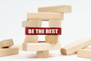 Beyaz yüzeyde tahtalardan yapılmış harabe bir kule var. Kırmızı bir plaketin üzerinde 100 adet güvenli yazı var.