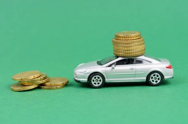 İş ve finans kavramı. Yeşil arka planda madeni paralar ve çatıda da bozuk paralar olan bir araba var..