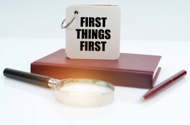 İş ve finans kavramı. Beyaz bir yüzeyde kırmızı bir defter ve kalem, bir büyüteç ve beyaz bir defter bulunur.