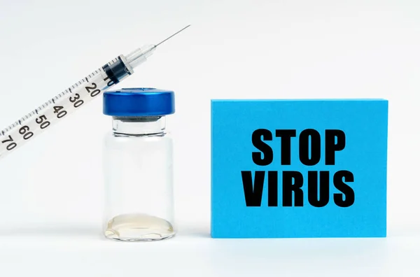 医学の概念 テーブルの上に注射器 注射器 碑文の青い看板があります Stopウイルス — ストック写真