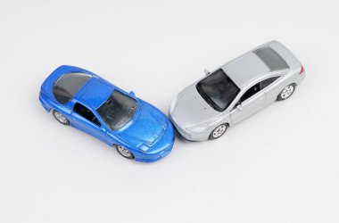 Olayın. Gümüş ve mavi oyuncak arabaların çarpışması. Beyaz arkaplanda izole.