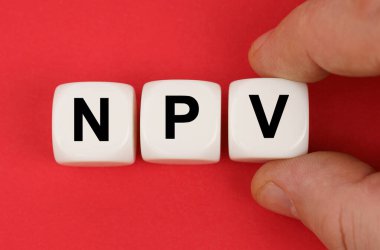 İş ve finans. Kırmızı yüzeyde NPV yazılı beyaz küpler var.