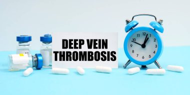 Tıp ve sağlık konsepti. Bir çalar saat, haplar, enjeksiyonlar ve üzerinde 