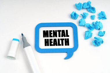 Beyaz bir yüzeyde buruşmuş mavi kağıt, bir işaret ve içinde 