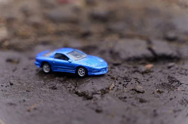 Голубая машина едет по дороге, разрушенной оползнем. — стоковое фото