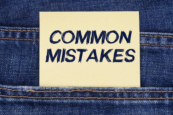 Aus einer Jeanstasche ragt ein Papier mit der Aufschrift - Common Mistakes — Stockfoto