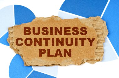 On the blue financial charts is a piece of cardboard that says - Business Continuity Plan