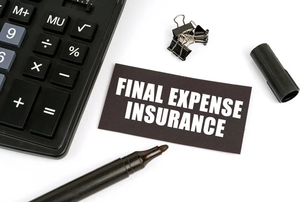 On a white table there is a calculator, a marker and a black plate with the inscription - Final Expense Insurance
