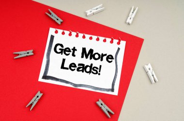 Business and finance concept. Clothespins and a sheet of notebook with the inscription - Get More Leads
