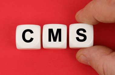 Business and finance. On the red surface, white cubes with the inscription - CMS