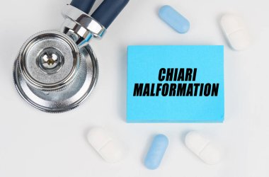 Medicine and health concept. On a white surface lie pills, a stethoscope and stickers with the inscription - Chiari malformation