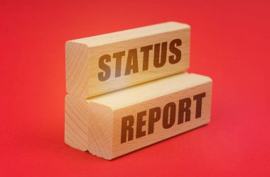On a red background, wooden blocks with the inscription - STATUS REPORT