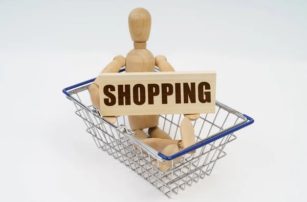 Business Finance Concept Wooden Man Sits Shopping Basket Holding Sign — Stock Photo, Image