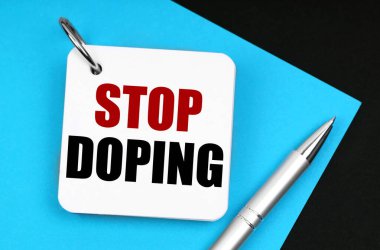 Tıp ve sağlık konsepti. Siyah yüzeyde mavi bir kağıt, bir kalem ve üzerinde yazı olan bir defter var.